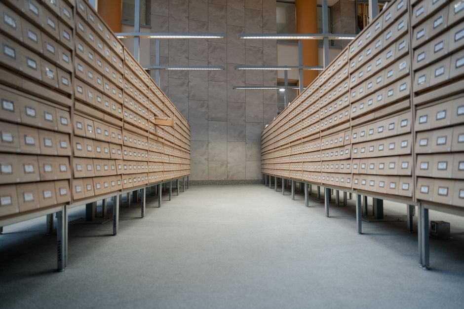 Spacious modern library archive with rows of wooden drawers for document storage.
